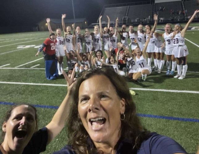 Coach Megan Lukasavage and the Girls Field Hockey Team cheer together after a game during the Fall 2022 season.